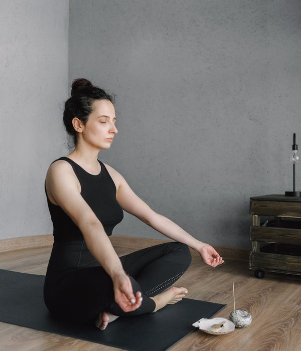 Person meditating peacefully in a bright, minimalist room.
